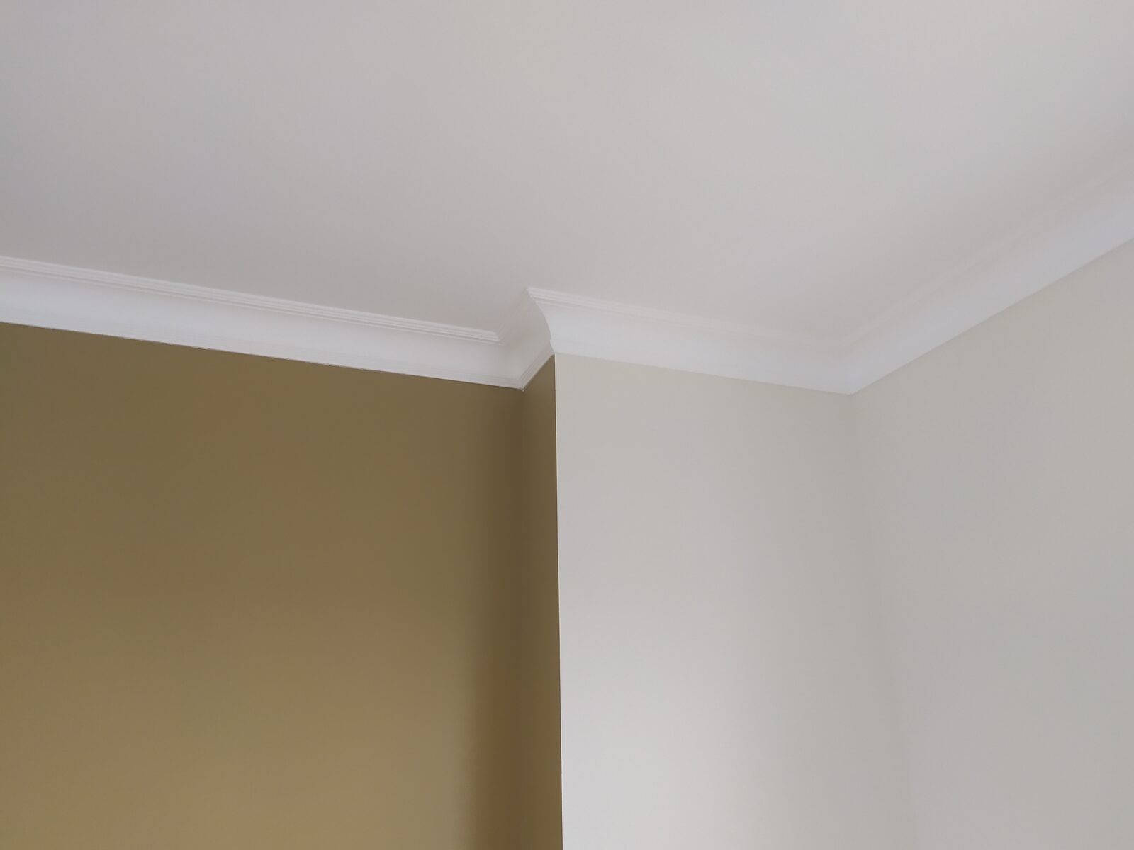 Peinture intérieure bicolore avec corniches et moulures repeintes en blanc